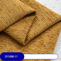 A close-up of folded, textured mustard yellow Heavy Weight Slub Chenille Fabric by Longan Craft, featuring a ribbed pattern on a light speckled surface. A label at the bottom left reads SY1090-11.