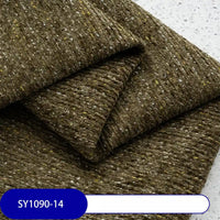 A close-up of Longan Craft's Heavy Weight Slub Chenille Fabric By The Yard, showing thick, textured brown material with yellow and gray flecks. Label at the bottom displays SY1090-14 in white text on a blue background.