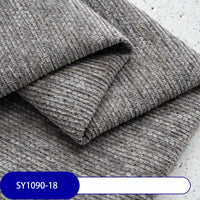 Close-up of Heavy Weight Slub Chenille Fabric by Longan Craft, folded to show its textured, ribbed grey surface. A blue label in the corner reads “SY1090-18”. Premium thick polyester chenille for upholstery use.