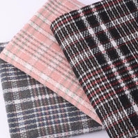 Three folded pieces of Heavyweight Cotton Checked Flannel Fabric by Longan Craft in pink, black-and-red, and gray tones are stacked together, each displaying unique checkered patterns and textures. Crafted from polyester brushed mammoth flannel, these vintage fall winter fabrics are ideal for cozy projects or durable apparel.