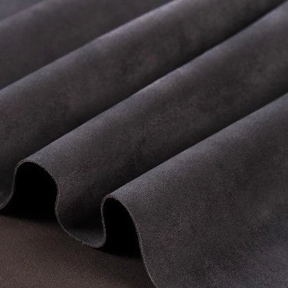 Close-up of Longan Craft Heavyweight Microfiber Faux Suede Fabric by the Yard in dark gray, highlighting its smooth, soft microfiber texture and gentle wavy folds—perfect for DIY clothing projects.