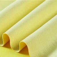 Close-up of Longan Craft’s Heavyweight Microfiber Faux Suede Fabric in a light yellow shade, showcasing its soft, brushed microsuede texture arranged in gentle, evenly spaced folds that create a wavy pattern across the image.