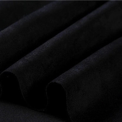 Close-up of black microfiber faux suede fabric by Longan Craft, highlighting its soft, brushed texture arranged in gentle folds that create shadows and lend a rich, luxurious look—evoking the depth and sophistication characteristic of heavyweight microsuede material, ideal for DIY clothing projects.