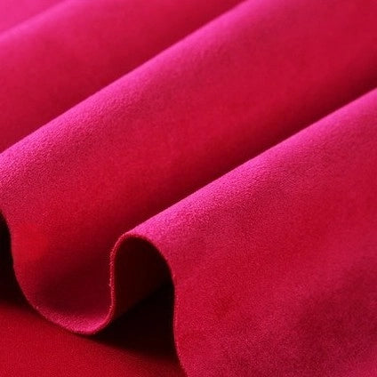 A close-up view of Longan Craft’s Heavyweight Microfiber Faux Suede Fabric By The Yard reveals gentle folds and a smooth, velvety texture, showcasing the rich vibrance and softness of this multicolor brushed microsuede material—perfect for DIY clothing projects.