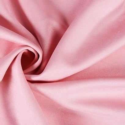 A close-up of Longan Craft’s heavyweight microfiber faux suede fabric by the yard, featuring soft folds and a smooth, slightly shiny texture in light pink brushed microsuede—ideal for DIY clothing projects.