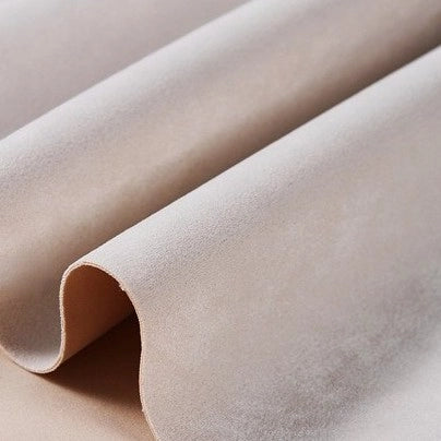 A close-up of Longan Craft Heavyweight Microfiber Faux Suede Fabric By The Yard in beige, featuring soft, multicolor brushed microsuede texture with gentle folds and a smooth surface—ideal for DIY clothing projects.