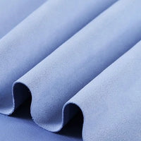 Close-up of the Longan Craft Heavyweight Microfiber Faux Suede Fabric by the Yard in light blue, highlighting its soft, smooth texture with gentle waves and folds—perfect for DIY clothing projects.