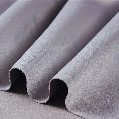Close-up of heavyweight microfiber faux suede fabric by the yard from Longan Craft in light gray, featuring gentle, soft folds that showcase its smooth and plush texture—resembling the luxurious feel of multicolor brushed microsuede material.