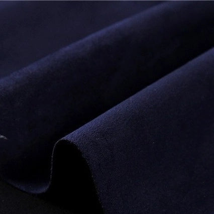 A close-up of Longan Craft’s Heavyweight Microfiber Faux Suede Fabric by the yard in dark navy, highlighting the soft, brushed microfiber texture and subtle sheen of the multicolor imitation suede material, with gentle diagonal folds visible across the surface—ideal for DIY clothing projects.