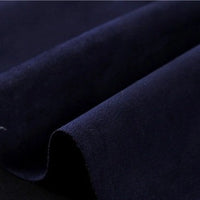 A close-up of Longan Craft’s Heavyweight Microfiber Faux Suede Fabric by the yard in dark navy, highlighting the soft, brushed microfiber texture and subtle sheen of the multicolor imitation suede material, with gentle diagonal folds visible across the surface—ideal for DIY clothing projects.
