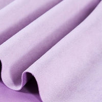Enjoy the luxurious feel of Longan Craft’s Heavyweight Microfiber Faux Suede Fabric By The Yard, a soft imitation suede material in a light purple shade with a sumptuous, velvety texture and gentle wavy folds. This multicolor brushed microsuede offers both durability and elegance, making it perfect for upholstery or DIY clothing projects.