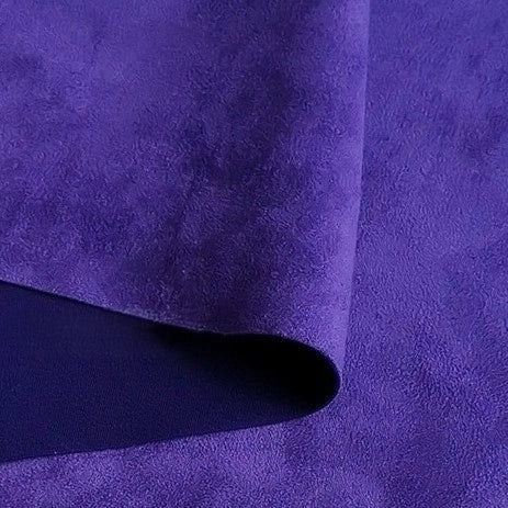 Close-up of a folded piece of vibrant purple Heavyweight Microfiber Faux Suede Fabric By The Yard by Longan Craft, highlighting its soft brushed surface and smooth heavy texture—perfect as an upholstery fabric or for DIY clothing projects that need high-quality imitation suede.