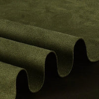 Close-up of the Longan Craft Heavyweight Microfiber Faux Suede Fabric by the Yard, with multicolor brushed microsuede draped in smooth, rounded waves against a dark background—showcasing its soft texture and rich green hue. This soft imitation suede material is an ideal choice for DIY clothing projects.