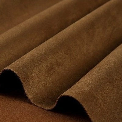 A close-up of Longan Craft’s Heavyweight Microfiber Faux Suede Fabric by the yard in a brown shade, artfully arranged in gentle, wavy folds to highlight its smooth, velvety texture and rich earthy tone—perfect for DIY clothing projects.
