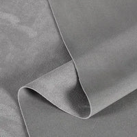 A close-up of Longan Craft’s Heavyweight Microfiber Faux Suede Fabric By The Yard in light grey, slightly folded to highlight the soft texture and subtle sheen of this multicolor brushed microsuede material—ideal for DIY clothing projects.