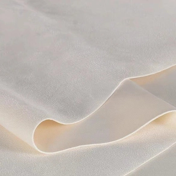A close-up of Longan Craft’s Heavyweight Microfiber Faux Suede Fabric by the yard displays soft, flowing folds and a smooth, multicolor brushed microsuede texture—ideal for DIY clothing projects.