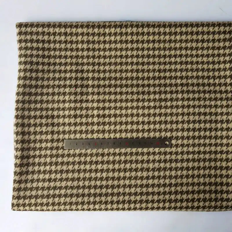 The Longan Craft Houndstooth Mammoth Flannel Fabric by the yard, a soft beige and brown brushed polyester cotton blend, is shown laid flat with a metal ruler on a plain light background for scale.