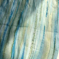 Introducing the Irregular Stripe Printed Ramie Fabric By The Yard by Longan Craft—a close-up showcases its lightweight, sheer texture with vertical, watercolor-like stripes in blue, green, and beige. This breathable ramie material features a soft, flowing pattern of irregular stripes, making it the ideal choice for airy and elegant dressmaking projects.