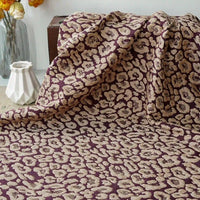 Leopard Embossed Brocade Fabric by Longan Craft, a vintage stretch jacquard brocade for dressmaking, displayed with a white geometric vase and flowers in the background.