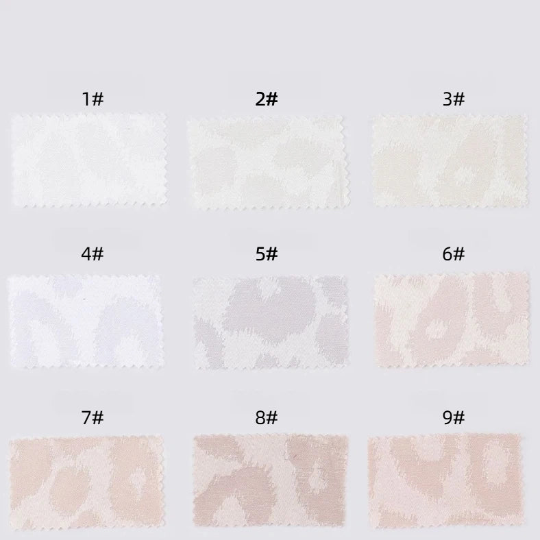 Nine Leopard Jacquard Satin fabric swatches by Longan Craft, labeled 1#–9#, display subtle animal prints in shades from white to beige and cream. Multicolor polyester satin is soft, smooth, and ideal for DIY shirts. Arranged in three rows on a light gray background.