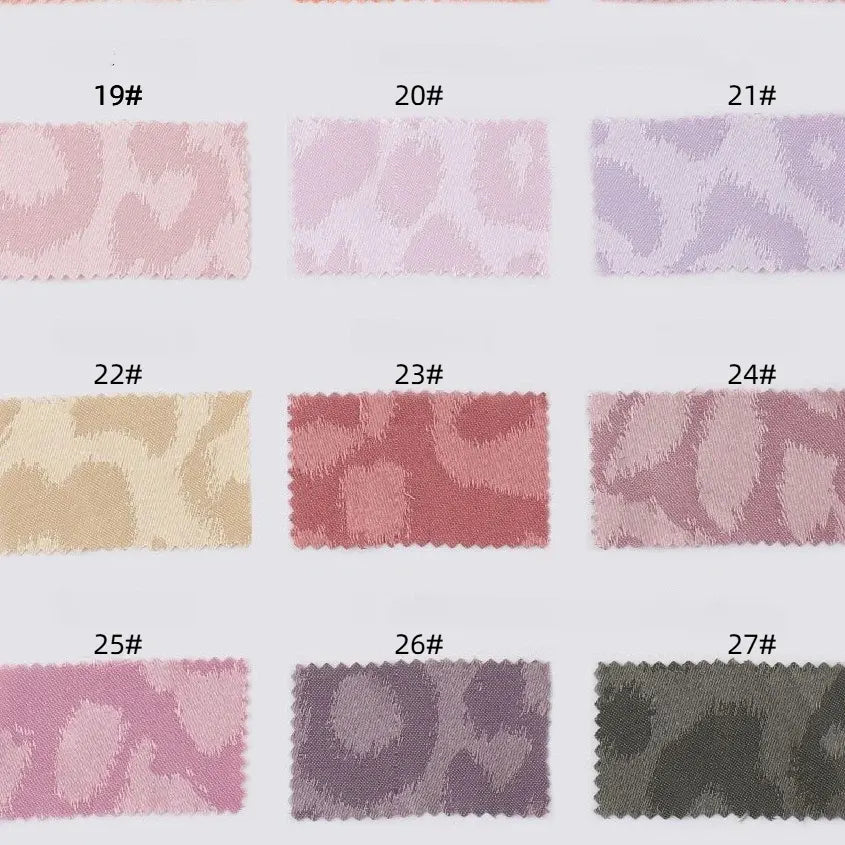 A grid of Longan Craft Leopard Jacquard Satin Fabric swatches (#19–27) in pastel and muted colors, each showing elegant animal print patterns. This soft multicolor polyester satin is perfect for DIY shirts and projects.