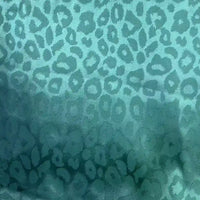 Leopard Jacquard Satin Fabric By The Yard by Longan Craft features a multicolor animal jacquard satin with a shiny, textured leopard print. Ideal for DIY shirts, the light enhances its soft sheen and shadow effects across the material.