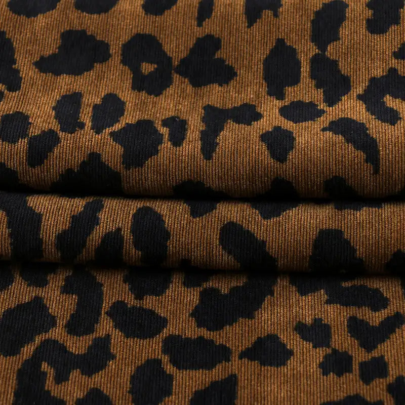 Close-up of Longan Craft’s Leopard Print Corduroy Fabric by the Yard, a multicolor printed corduroy—showcasing its textured folds. This fashionable material is perfect for kids’ clothing and creative sewing projects.