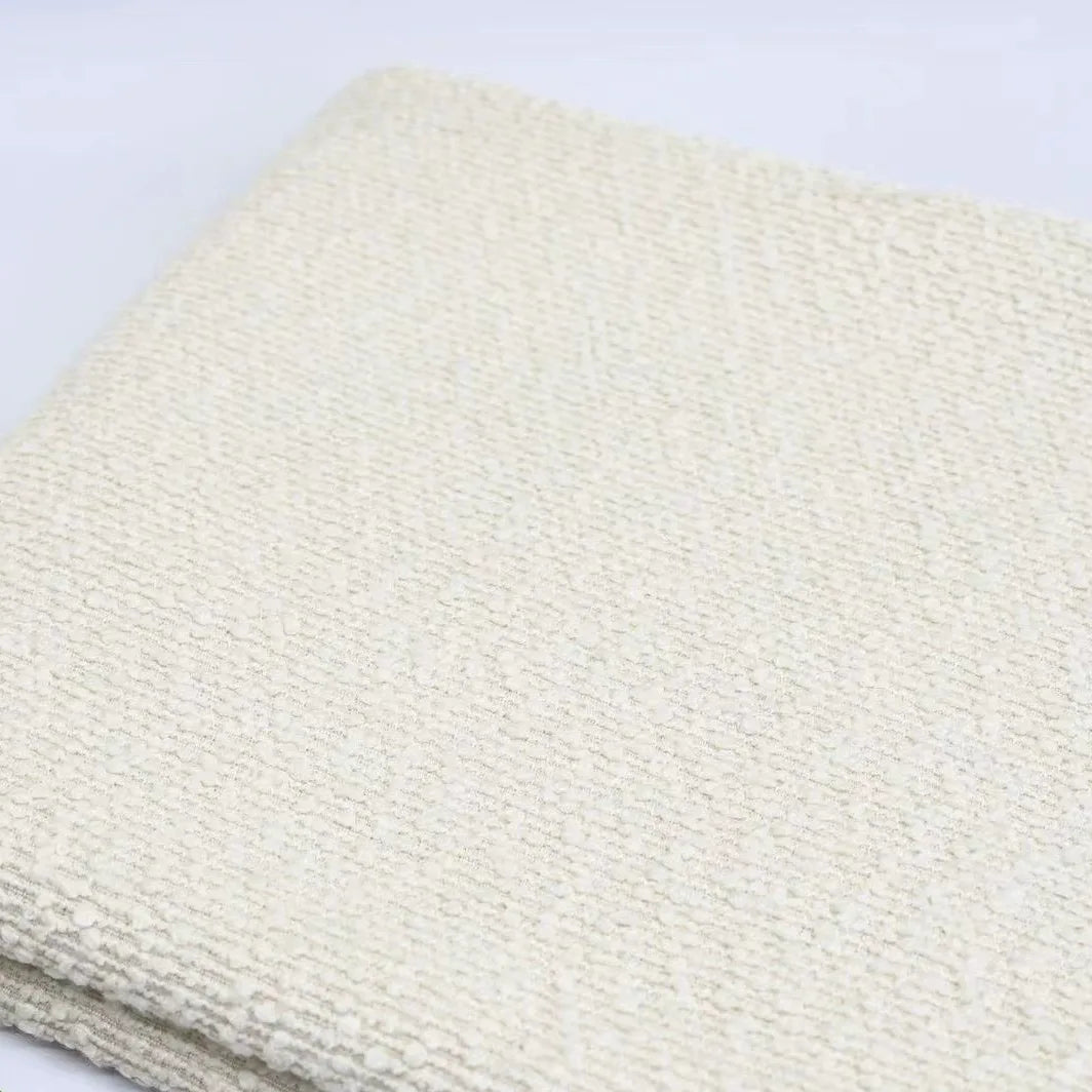 Off-white Linen Grain Boucle Fabric By The Yard with a textured boucle finish and a linen grain folded over itself.