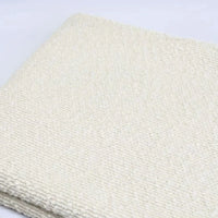 Off-white Linen Grain Boucle Fabric By The Yard with a textured boucle finish and a linen grain folded over itself.