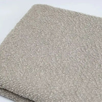 Folded square of beige Linen Grain Boucle Fabric with a distinctive linen grain texture.