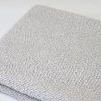 Folded light gray Linen Grain Boucle Fabric By The Yard with a textured, nubby surface.