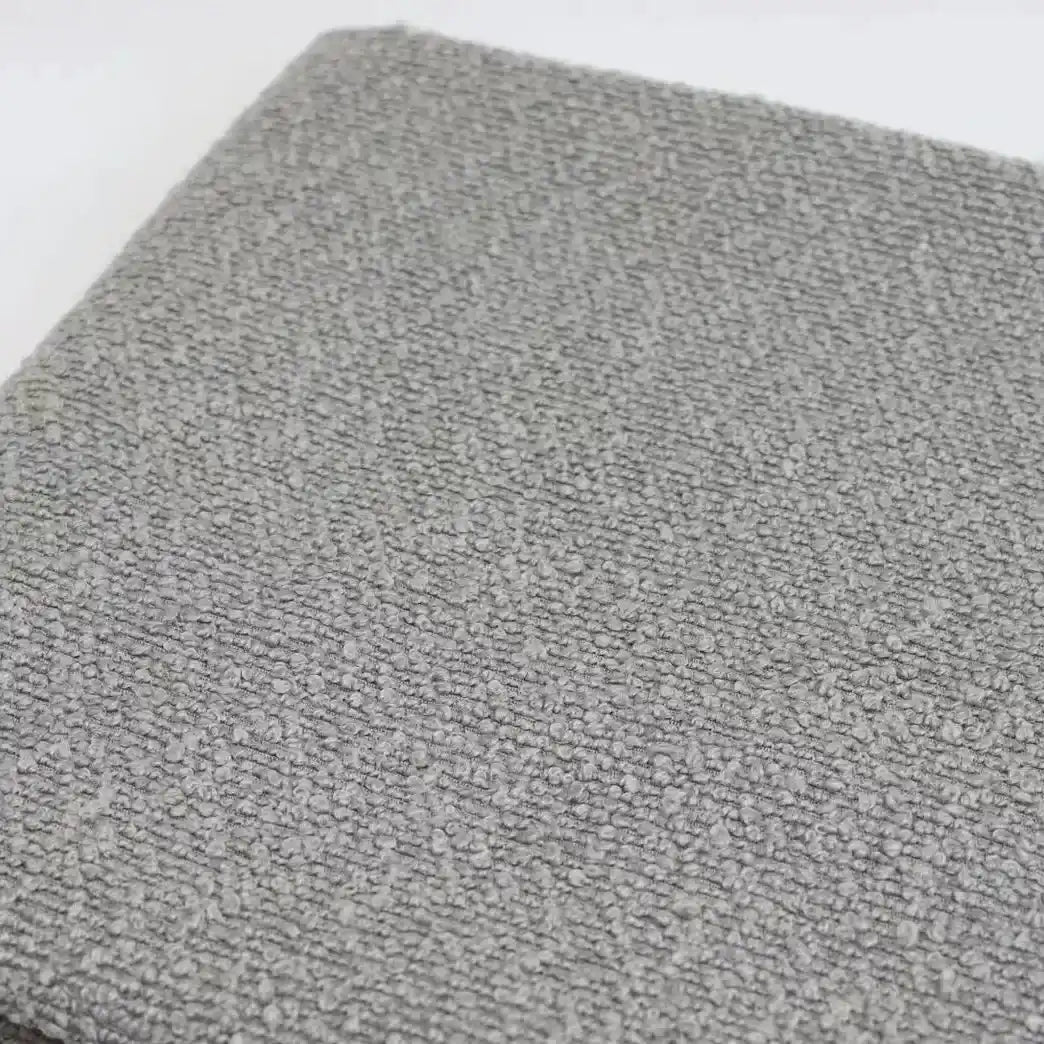 A close-up of grey textured Linen Grain Boucle Fabric By The Yard upholstery.