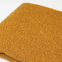 Folded piece of golden-yellow textured Linen Grain Boucle Fabric By The Yard.