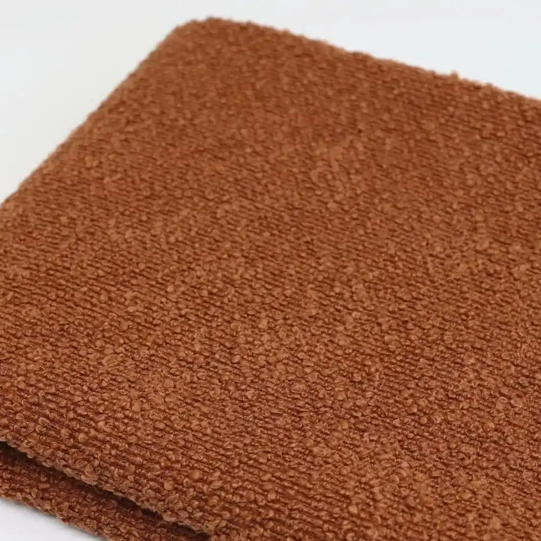 Folded piece of brown textured Linen Grain Boucle Fabric By The Yard with a prominent linen grain.