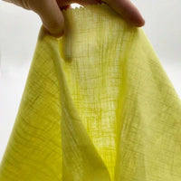 A hand displays Longan Craft's Linen and Viscose Fabric By The Yard—semi-transparent, lightweight multicolor viscose cellulose—against a white background, highlighting its texture and weave, ideal for summer garments.