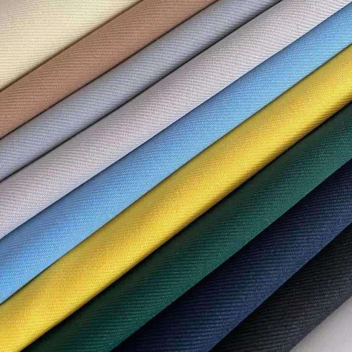 A close-up of Longan Craft's Matte Finish Gabardine Fabric by the yard shows neatly stacked twill weave rolls in beige, pink, and navy, highlighting its smooth, wrinkle-resistant texture and vibrant colors—ideal for jackets and versatile projects.
