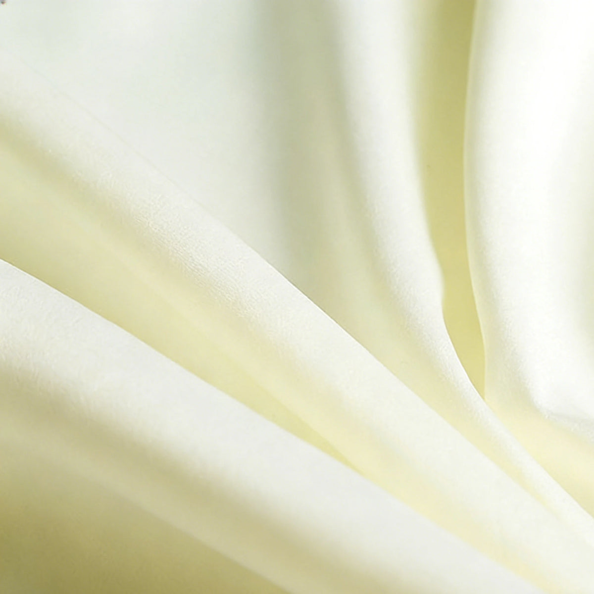 Close-up of Longan Craft Matte Satin Fabric By The Yard, showcasing its pale yellow color, gentle folds, subtle sheen, and smooth texture—ideal for comfortable bridesmaid dresses and elegant solid color outfits.