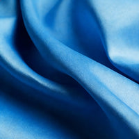 Close-up of Longan Craft Matte Satin Fabric By The Yard, featuring a smooth satin texture and gentle folds in a solid blue hue—perfect for comfortable, elegant bridesmaid dresses and other special occasion garments.