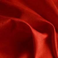 A close-up of Longan Craft’s Matte Satin Fabric By The Yard shows its vibrant red color, smooth texture, and gentle folds—ideal for solid color bridesmaid dresses and other comfortable garment projects.