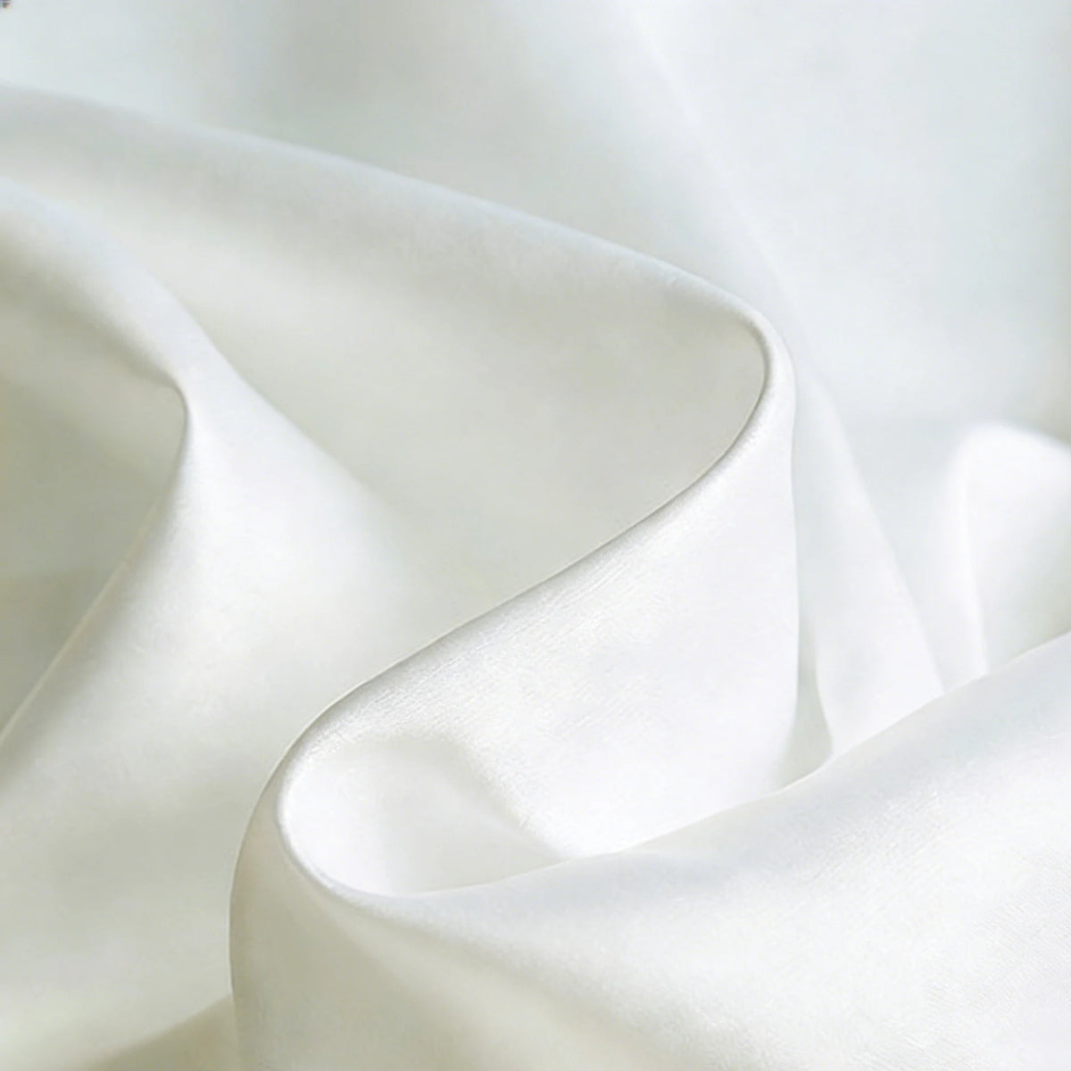 A close-up of Longan Craft Matte Satin Fabric by the Yard shows its smooth, solid color surface with gentle folds and soft shadows—an elegant, comfortable textile ideal for bridesmaid dresses.