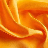 A close-up of Longan Craft Matte Satin Fabric By The Yard in a vibrant orange, featuring smooth folds and a soft, comfortable satin texture—ideal for bridesmaid dresses and elegant attire.