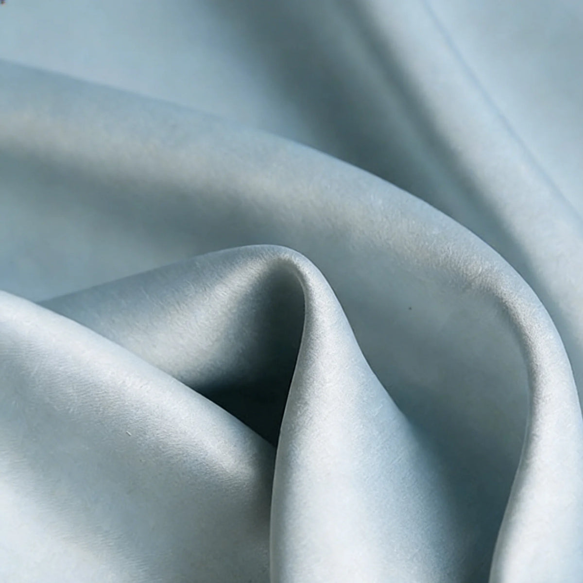 Close-up of Matte Satin Fabric By The Yard from Longan Craft in light blue, featuring soft folds and a subtle sheen—ideal for comfortable, elegant bridesmaid dresses or other garments.