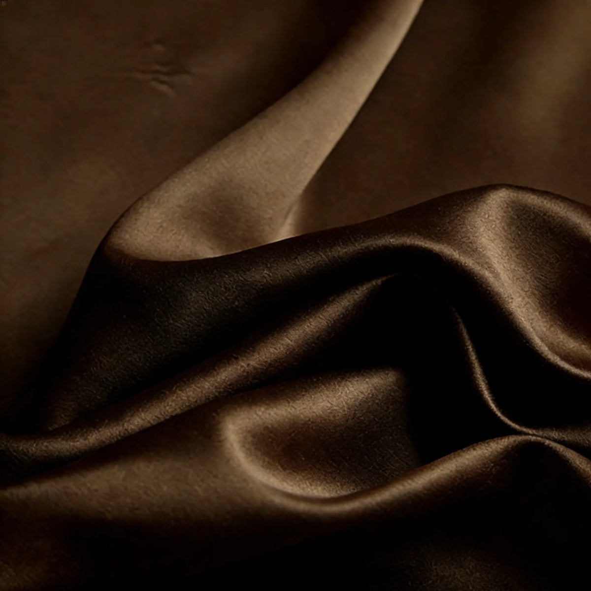 A close-up of Longan Craft's Matte Satin Fabric shows smooth, dark brown material with gentle folds and a subtle sheen—ideal for comfortable bridesmaid dresses and special occasion wear.