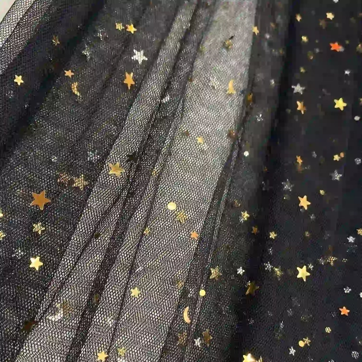 Close-up of Longan Craft's Moon Star Sequins Tulle Fabric By The Yard, multicolor glitter tulle material with gold and silver star and moon details—shimmery pleated layers perfect for stage costumes or evening gowns.