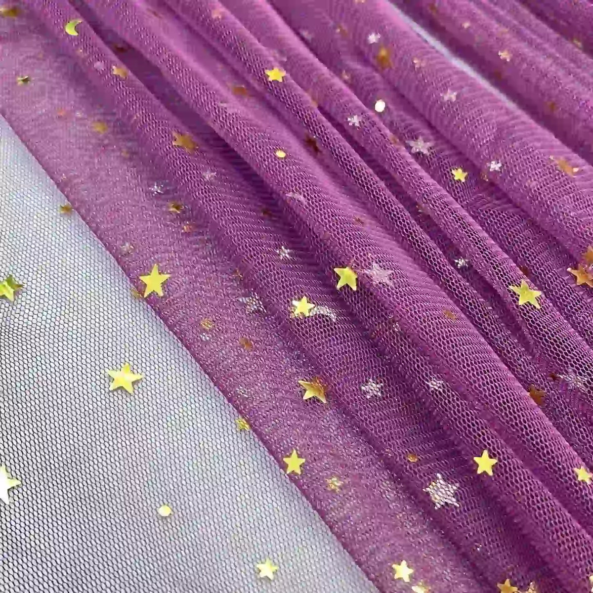Moon Star Sequins Tulle Fabric by Longan Craft features multicolor glitter stars, perfect for stage costumes and evening wear, displayed on a white mesh surface. Sold by the yard.