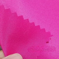 A close-up of two bright pink pieces of Longan Craft Multicolor 300D Oxford Fabric with zigzag edges; a person’s fingers hold the water-repellent, PU-coated polyester layers made for bags and backpacks.