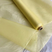A roll of Longan Craft Multicolor 8 Momme Organza Silk Fabric By The Yard, pure mulberry silk, partially unrolled on a white surface. This translucent, airy luxury fabric is perfect for crafting elegant dresses and evening gowns.