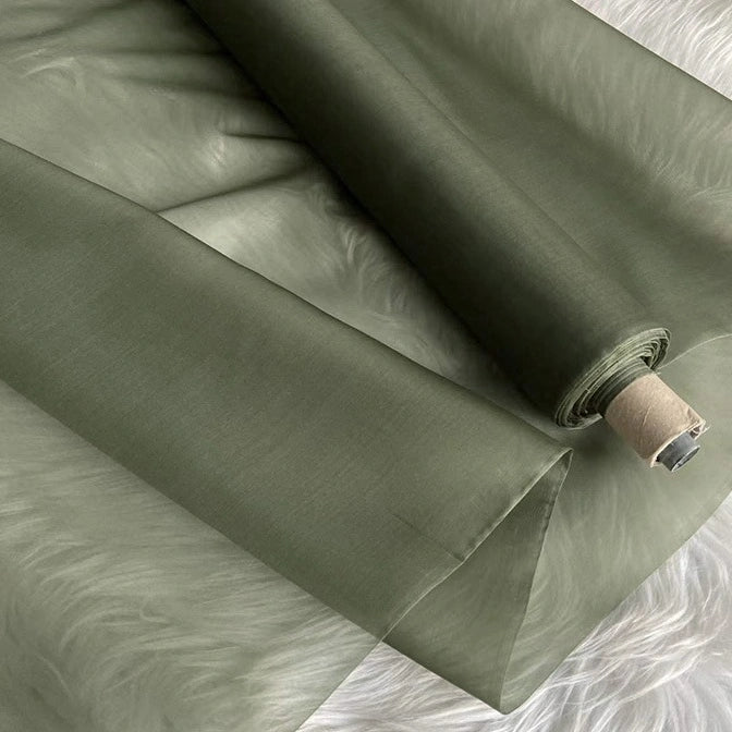 A roll of Multicolor 8 Momme Organza Silk Fabric by Longan Craft lies partially unrolled, revealing its smooth, slightly shiny pure mulberry silk texture—ideal luxury material for elegant dresses.