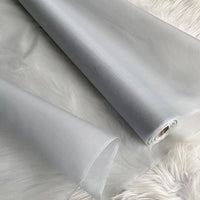 A yard of Longan Craft Multicolor 8 Momme Organza Silk Fabric—pure mulberry silk, perfect for luxury dresses—unrolls on a white furry background, showing its delicate texture and subtle sheen.