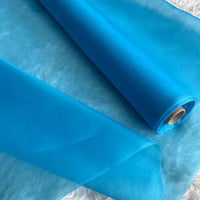 A yard of Longan Craft’s Multicolor 8 Momme Organza Silk Fabric—a pure mulberry silk material—lies unrolled, displaying its luxurious translucent texture, perfect for crafting elegant dresses.